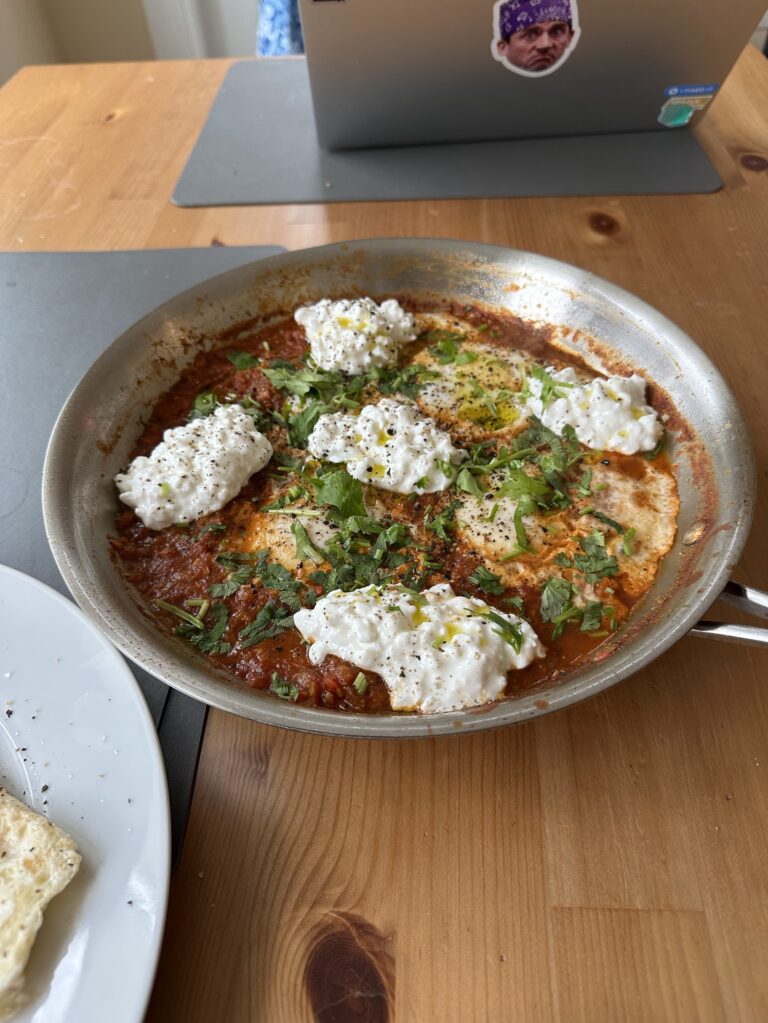 Shakshuka with cottage cheese on a brown table in a steel pan