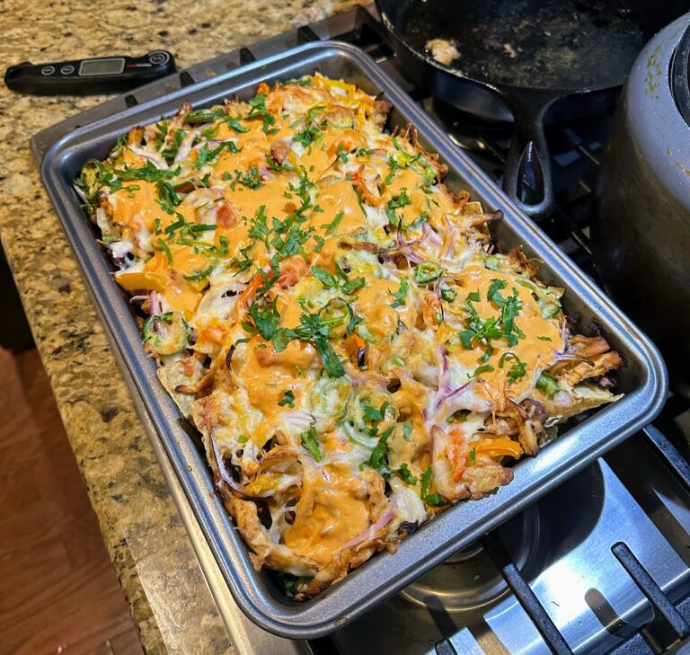 Sheet pan with loaded chicken nachos topped with cheese